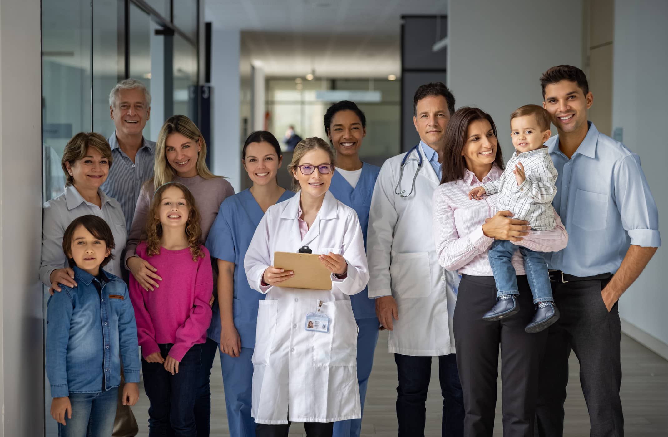 Happy group of doctors and patients at the hospital